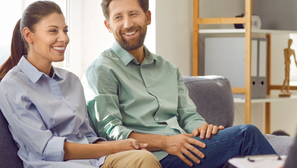 A happy couple talking to a fertility doctor